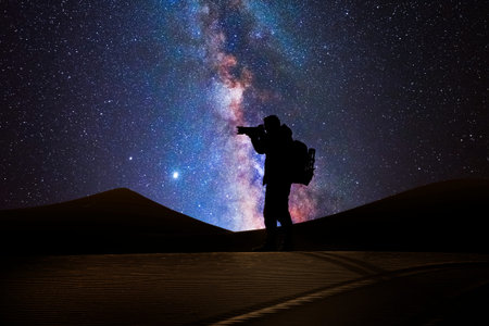 Photographer in the desert with the milky way in the background