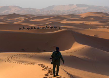 Man walking through the desert dunes
