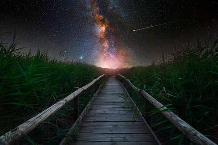 Wooden walkway and the milky way in the backgroundの写真素材