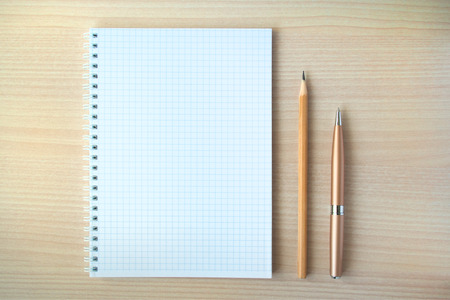 Pencil and pen with open clear notepad on wooden table, copyspace
の写真素材