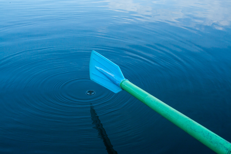 Blue paddle in water with reflections of the skyの写真素材