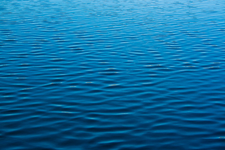 ripple blue water texture with reflections of the skyの写真素材