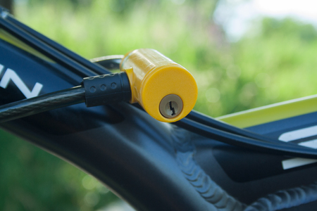 Yellow plastic lock fixed on a bicycle close upの写真素材