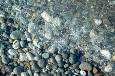 Stone beach with waves. Multi colore stones on beachの写真素材
