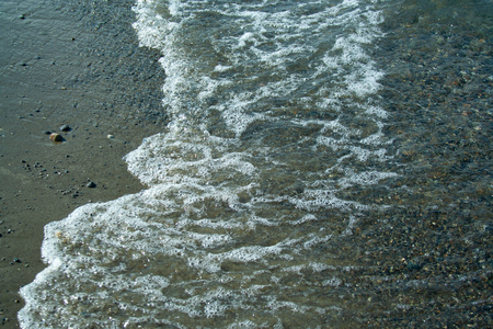 Stone beach with waves. Multi colore stones on beachの写真素材
