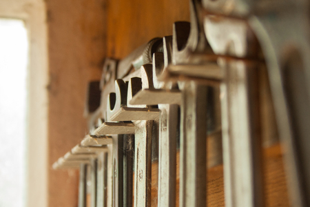 Old rusty spanners are hanging in a row in the shedの写真素材