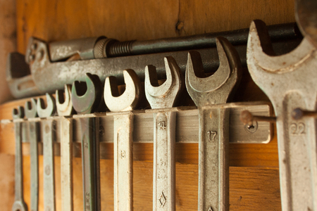 Old rusty spanners are hanging in a row in the shedの写真素材
