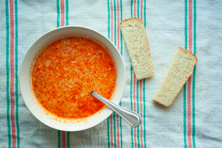 Soup with sour cream and bread in the background close-up on a towel. Delicious cabbage soup with a spoonの写真素材