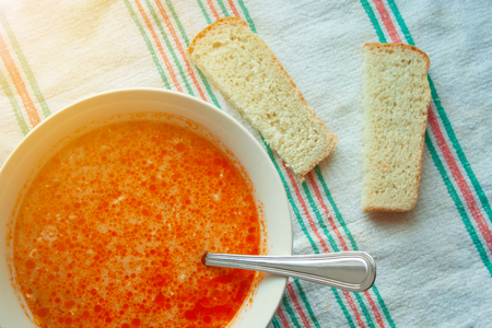 Soup with sour cream and bread in the background close-up on a towel. Delicious cabbage soup with a spoonの写真素材