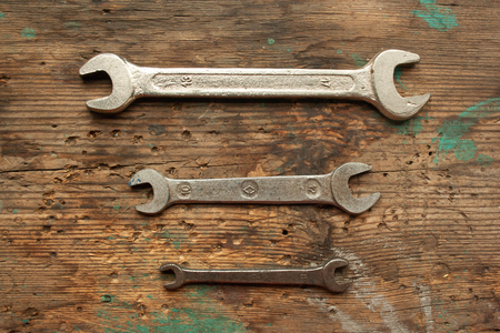 Wrenches on old battered wooden table top view. Work conceptの写真素材