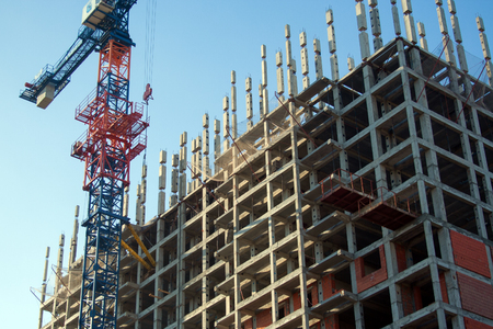 Construction crane in the process of building a new residential building. Construction of an apartment building bottom viewの写真素材