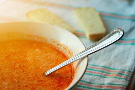 Soup with sour cream and bread in the background close-up on a towel. Delicious cabbage soup with a spoonの写真素材