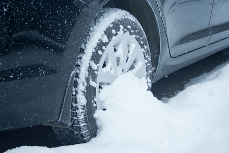 Wheel of black car at snow close up. Winter driving conceptの写真素材