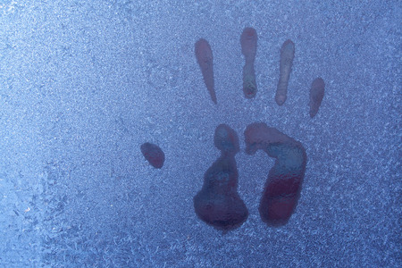 Hand print on icy window. Close up of hand printの写真素材
