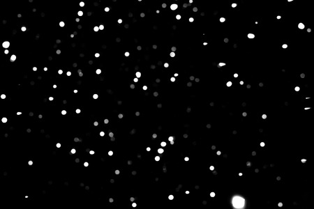 Falling snowflakes texture isolated on black backgroundの写真素材