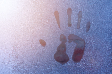 Hand print on icy window. Close up of hand printの写真素材