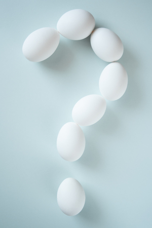 Question mark folded from white eggs on bright background. Conceptual photo. Easter celebrate symbol.の写真素材