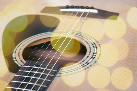 Close up of acoustic guitar with metal strings. Music concept. Hobby, leisure concept. Learn to play the guitar. Toned with bright colored bokeh roundsの写真素材