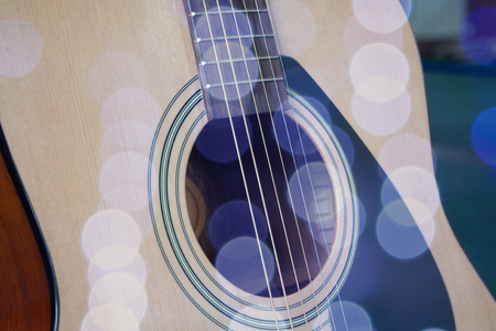 Close up of acoustic guitar with metal strings. Music concept. Hobby, leisure concept. Learn to play the guitar. Toned with bright colored bokeh roundsの写真素材