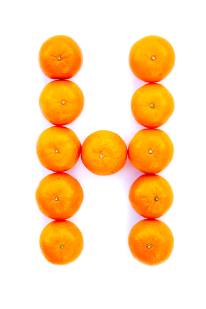 Letter solved with tangerines isolated on white background. Mandarine Â«HÂ» letterの写真素材
