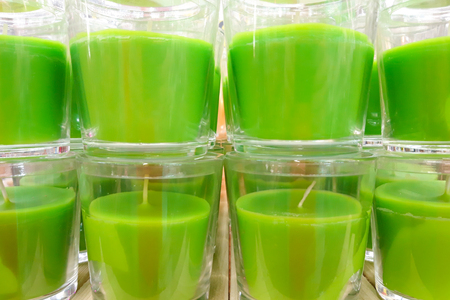 Group of green aroma candles in plastic pots close up. Relaxation, calm and aromatherapy symbol. Green spa candles.の写真素材