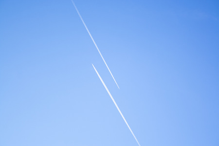 Two airplanes in the blue sky fly to the different ways. Creative concept of relationship. Paths diverged symbol.の写真素材