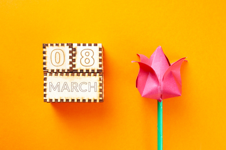 wooden cubes and paper tulip with the inscription March 8 on orange background. 8 march conceptの写真素材