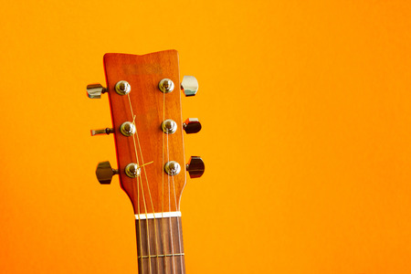 Head of acoustic guitar on orange background with copy space close upの写真素材