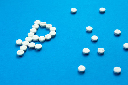 white pills in the shape of a ruble are scattered on a blue backgroundの写真素材