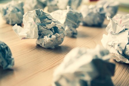 Many crumpled white paper balls on wooden table. Texture of crumpled paper balls.  Crumpled paper as brainstorming, creativity concept, mistakes and creation symbol. tonedの写真素材