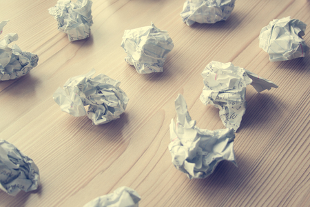Many crumpled white paper balls on wooden table. Texture of crumpled paper balls.  Crumpled paper as brainstorming, creativity concept, mistakes and creation symbol. tonedの写真素材