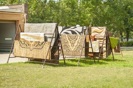 Colorful housÑ carpets hang on the sun outside. Cerpet sell, cleaning carpetsの写真素材