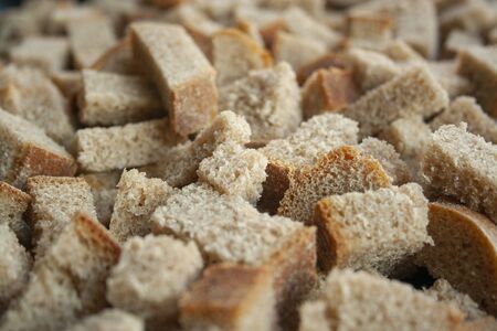 Sliced in cubes dark bread pieces crackers macro shot close up background. Bread texture. Bread backdropの写真素材
