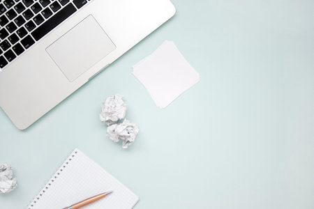 Work and creativity concept. Laptop, notepad, crumpled paper and pen top view flat lay photo with...