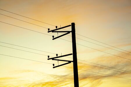 Electric pole shape against the sunset orange sky. Mobile communication, internet. electricity conceptの写真素材