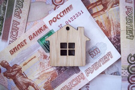 Mortgage, insurance, buying and rent, real estate business concept. Small wooden house toy on money rouble banknotes background top viewの写真素材