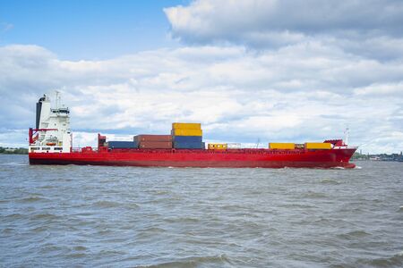 huge red barge with large containers on board. shipping cargo transportation by seaの写真素材