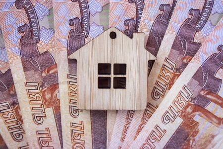 Mortgage, insurance, buying and rent, real estate business concept. Small wooden house toy on money rouble banknotes background top viewの写真素材