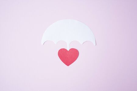 Red paper heart shape under white paper umbrella as life, health insurance concept. Assurance. insurance life symbolの写真素材