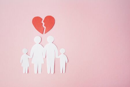 paper family cut out on bright pink background with broken heart above, family home, foster care, family mental health, divorce and family crisis conceptの写真素材