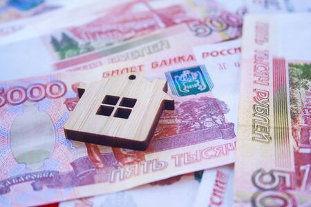 Mortgage, insurance, buying and rent, real estate business concept. Small wooden house toy on money rouble banknotes background side viewの写真素材