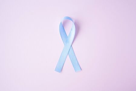Prostate cancer awareness blue ribbon on pink background. Men healthcare concept, men carcinoma symbol.の写真素材