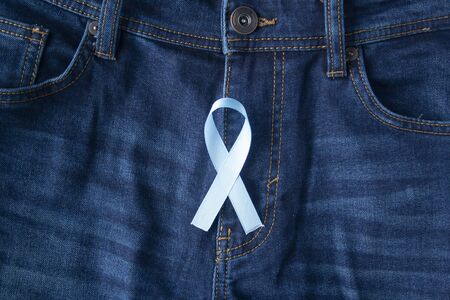 Prostate Cancer Awareness, light Blue Ribbon on male jeans fly background. Closeup, hope, cure, treatment, medical symbol. Blue ribbon on men crotchの写真素材