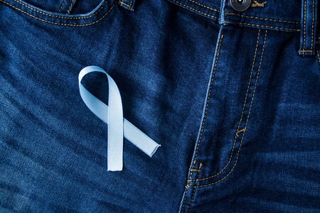 Prostate Cancer Awareness, light Blue Ribbon on male jeans fly background. Closeup, hope, cure, treatment, medical symbol. Blue ribbon on men crotchの写真素材