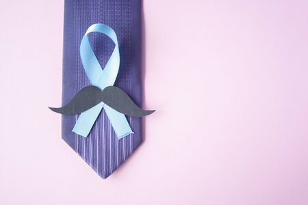 Prostate Cancer Awareness, light Blue Ribbon with mustache on blue men tie for support people living and illness. Men Healthcare and World cancer day concept. Men carcinoma health symbolの写真素材