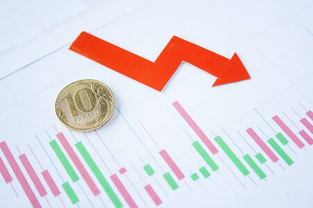 ten rouble coin on currency graph with red arrow down. exchange rate chart. ruble depreciation. Exchange rate of rouble fall. Rouble to dollarの写真素材