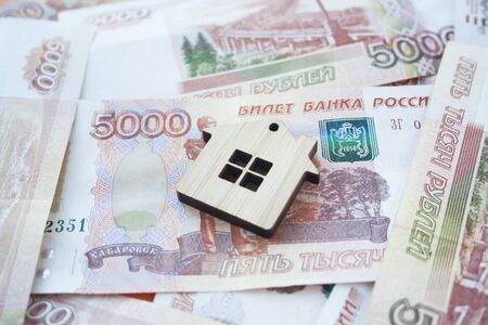 Mortgage, insurance, buying and rent, real estate business concept. Small wooden house toy on money rouble banknotes background side viewの写真素材