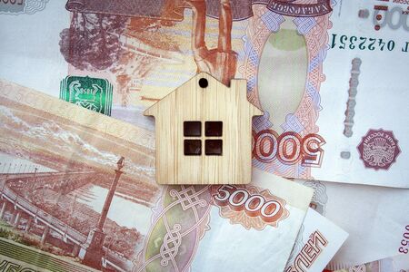 Mortgage, insurance, buying and rent, real estate business concept. Small wooden house toy on money rouble banknotes background top viewの写真素材