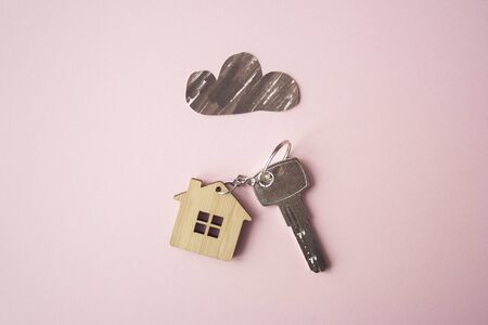 Paper dark cloud above the wooden house and key. Bad times, mortgage, no money concept. Flat lay. Top viewの写真素材