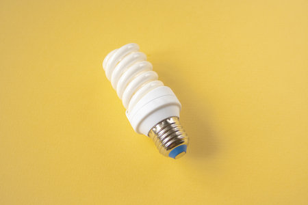 Energy saving light bulb on a yellow backgroundの写真素材